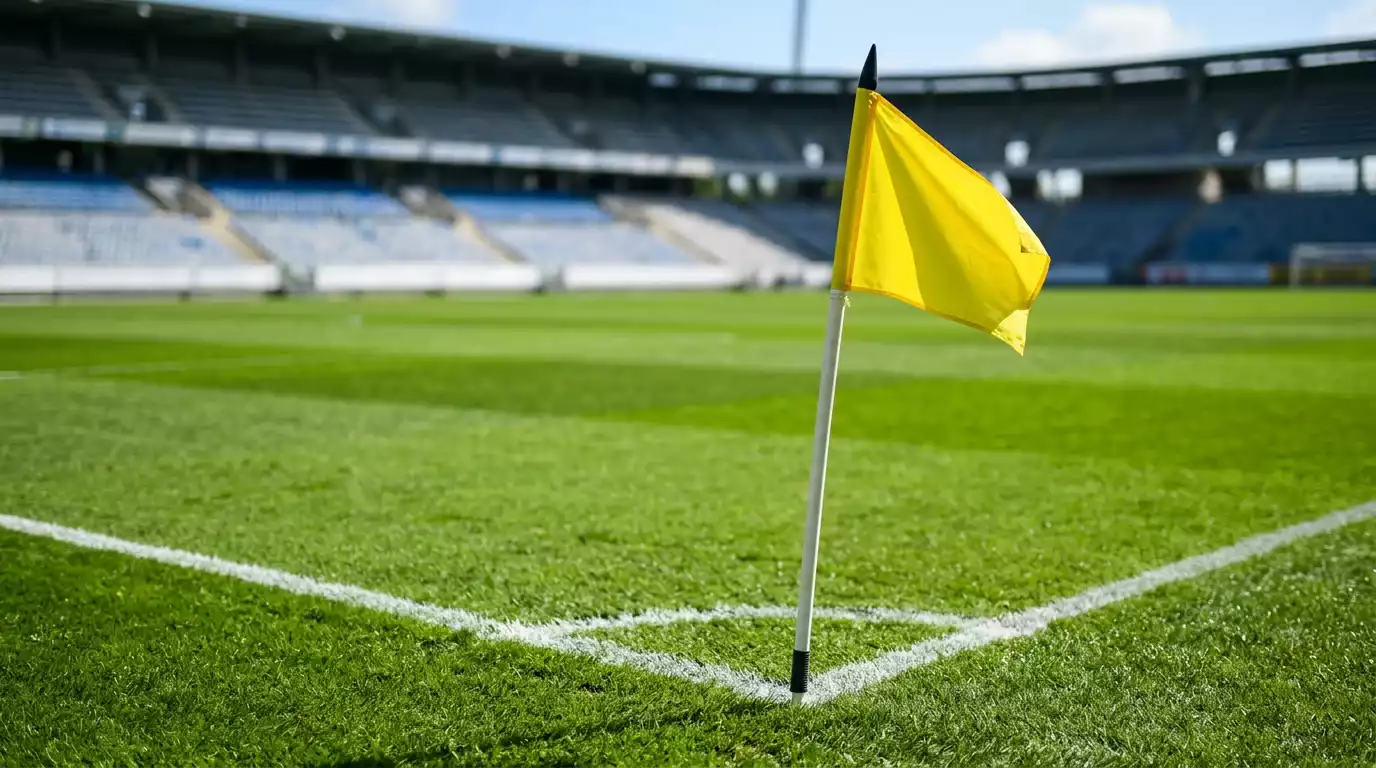 Banderín de córner amarillo clavado en el césped de un campo de fútbol
